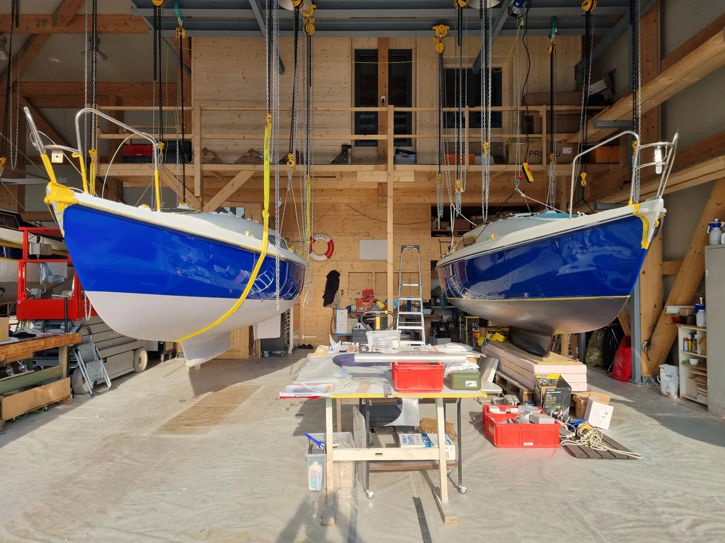 Zwei blaue Segelboote an den Hebeanlagen in der HSPi Werkstatt